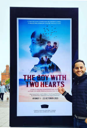 Hamed Amiri standing in front of The Boy With Hearts theatre billboard